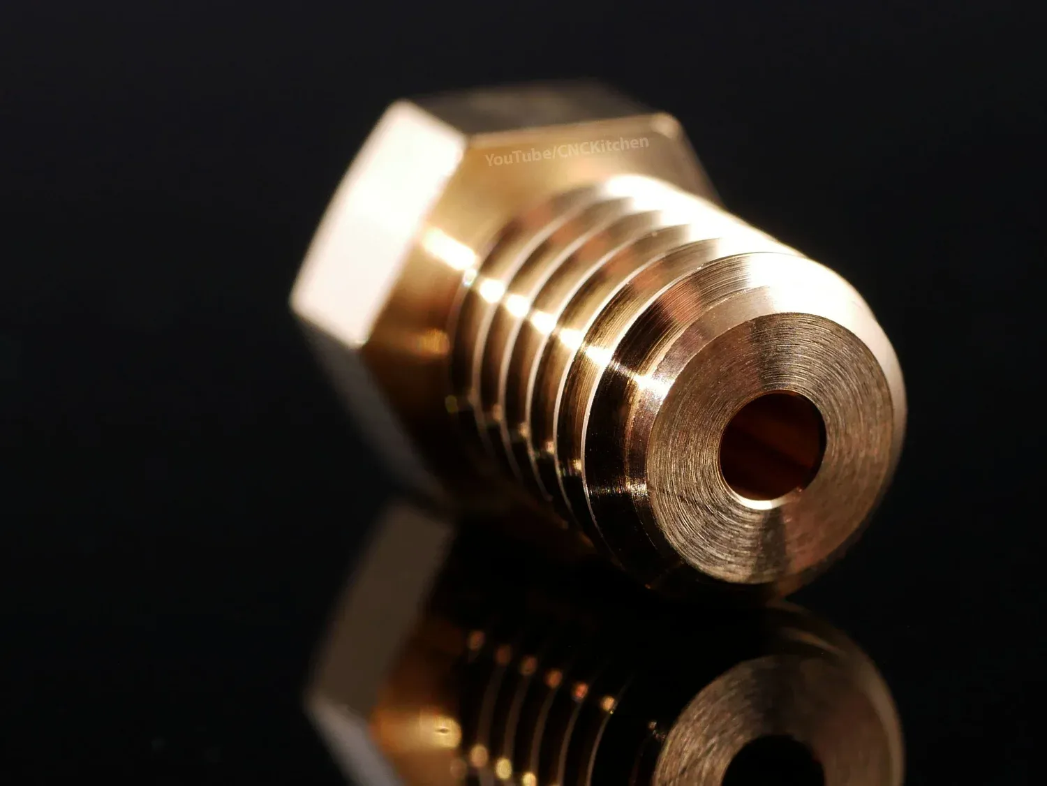 The same nozzle from the threaded end, showing the filament bore and the polished flanks