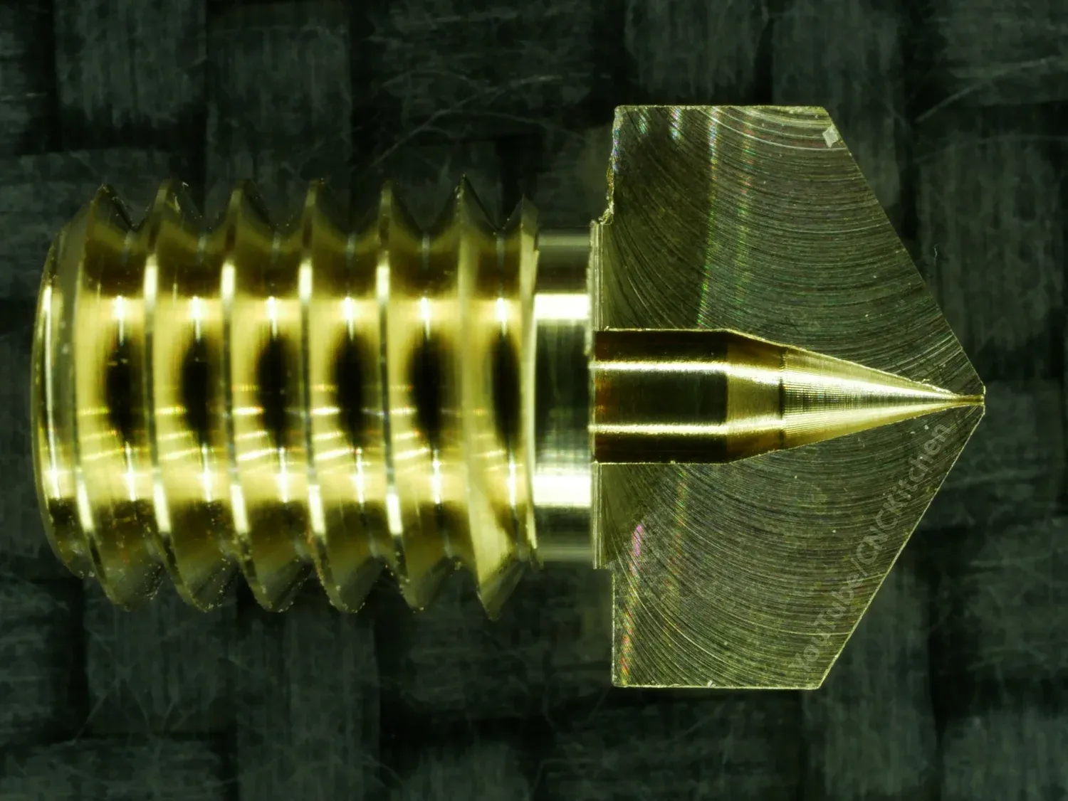 The 0.15 mm nozzle cut open on the CNC router, its drill taper noticeably pointier than an E3D's, with faint chatter marks in the cone