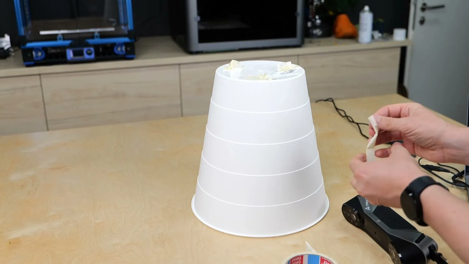 Crumbled-up painters tape stuck onto a featureless white cone