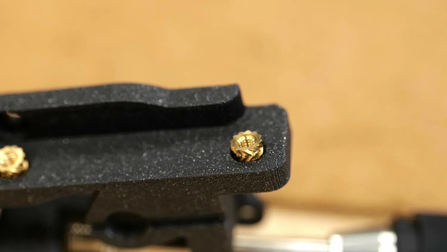 Heat-set insert sitting in an oversized hole in a black printed part
