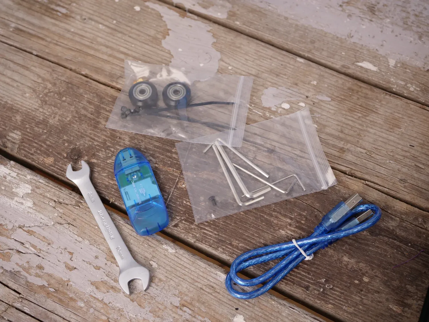 The accessory bag: spare wheels, hex keys, a spanner, an SD card reader and a USB cable, with no side cutter or filament sample
