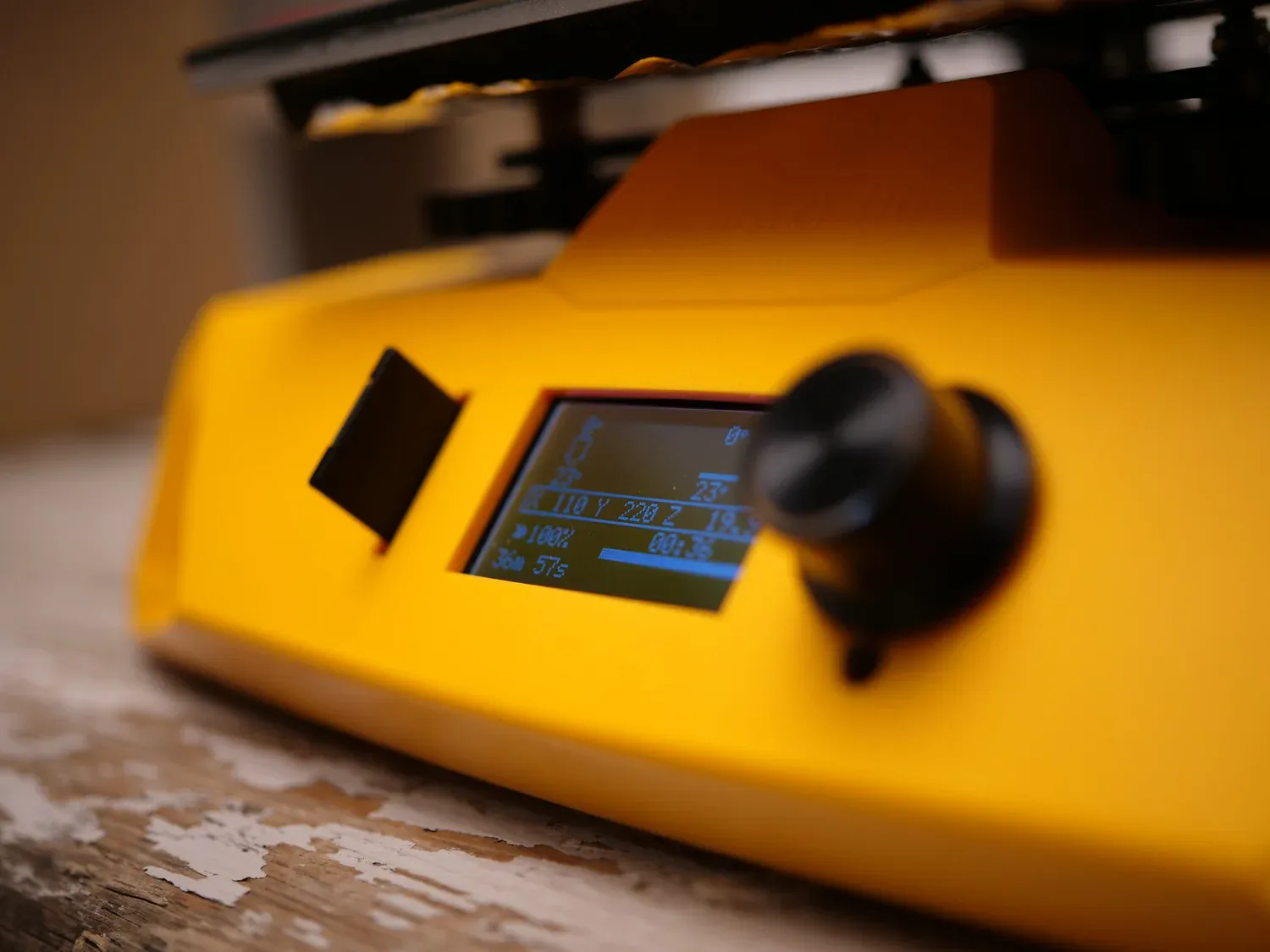 The dot-matrix screen and encoder wheel in the front housing, mid-print