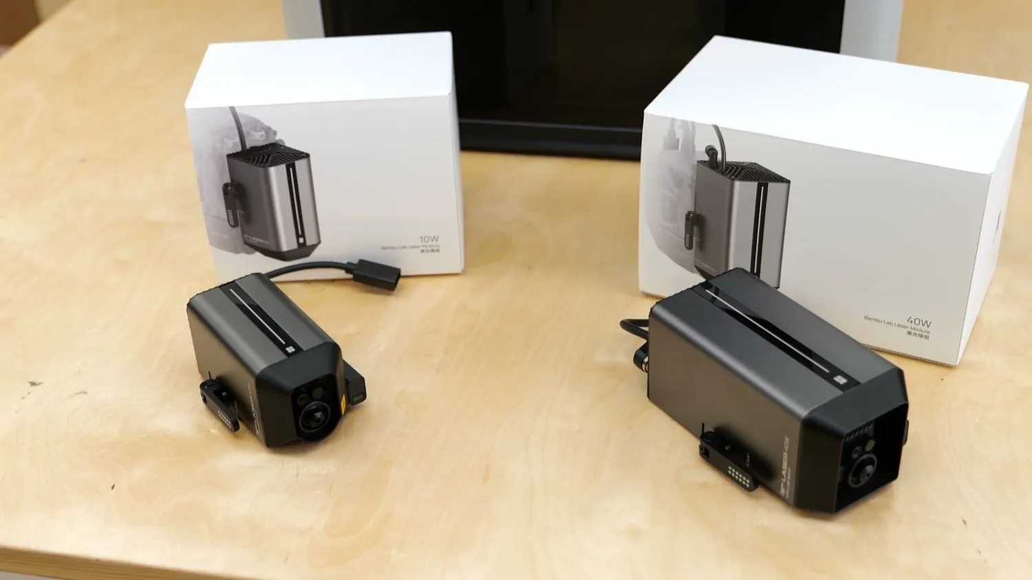 The 10 W and 40 W Bambu Lab laser modules in front of their boxes