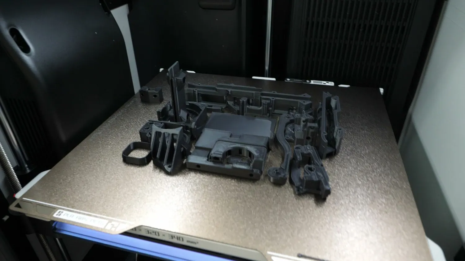 Black ASA parts on the build plate of the printer