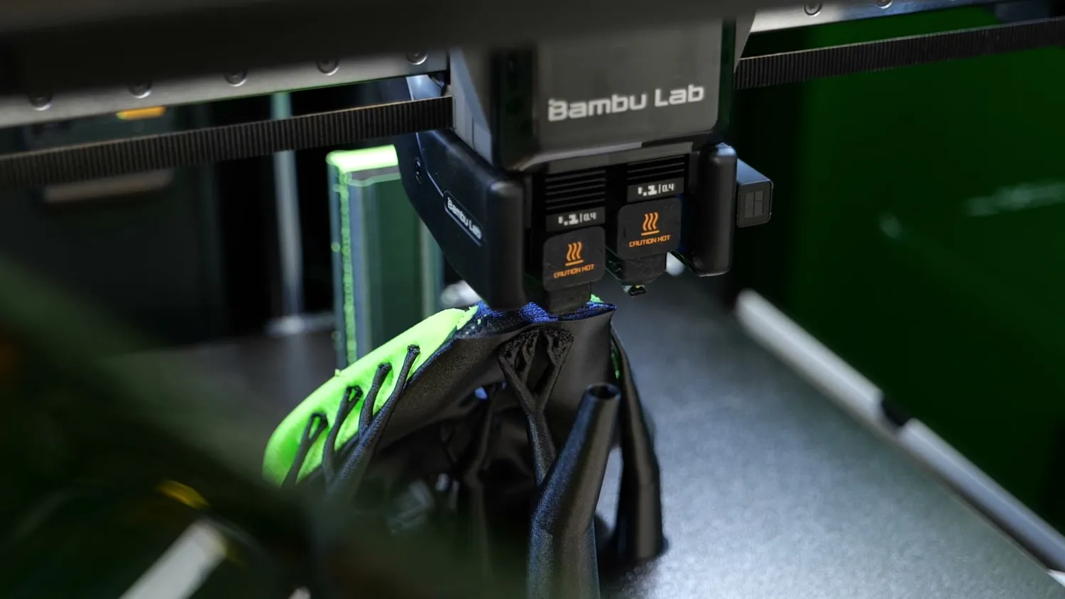 The H2D's dual-nozzle toolhead printing a two-material part