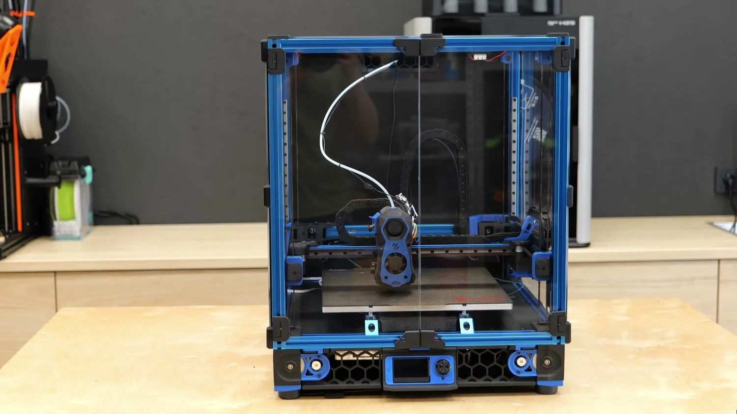 A blue Voron 3D printer standing on a workbench