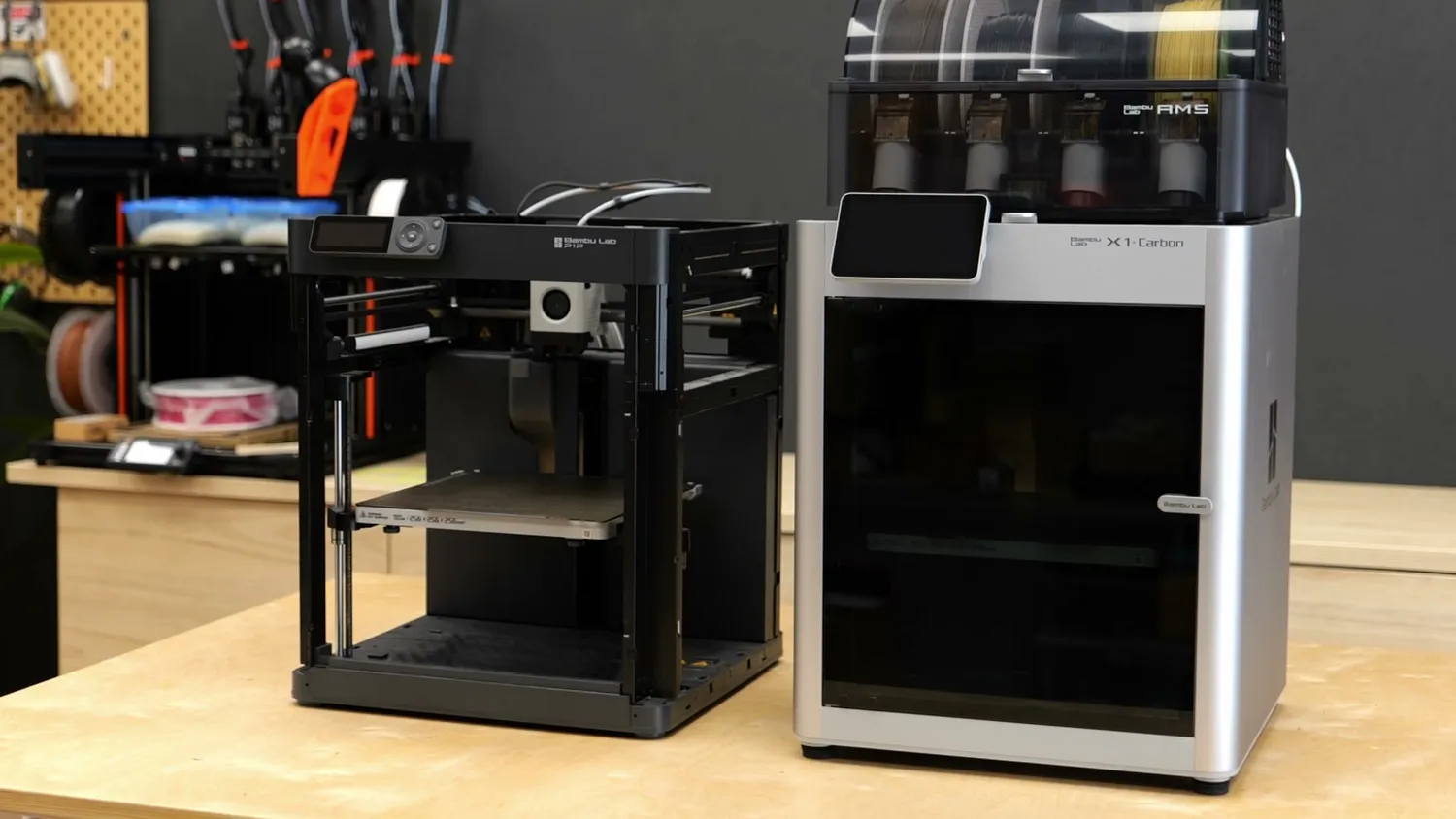 An open-frame P1P next to the enclosed X1 Carbon