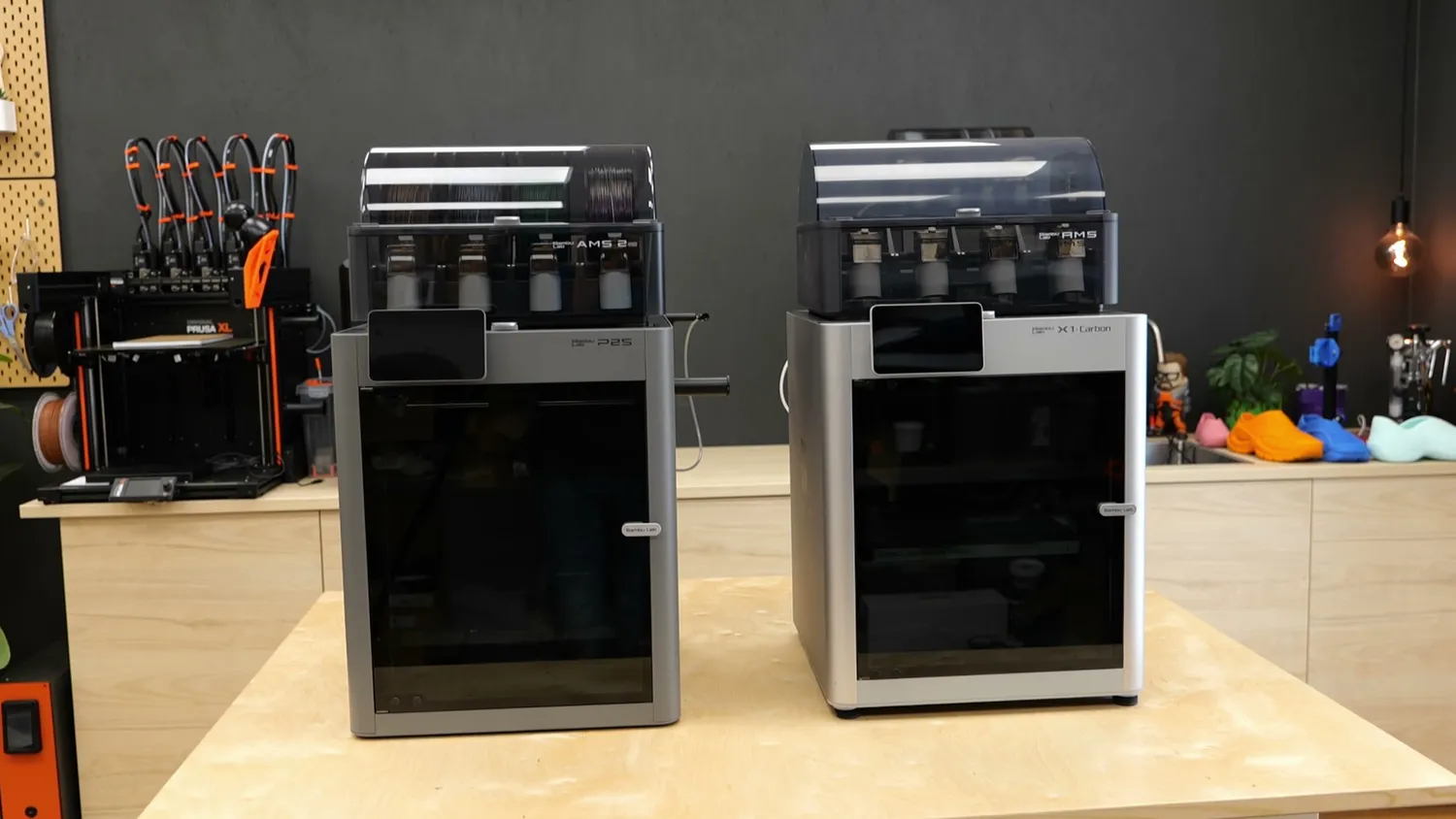 The P2S standing next to the Bambu Lab X1 Carbon, both with an AMS on top