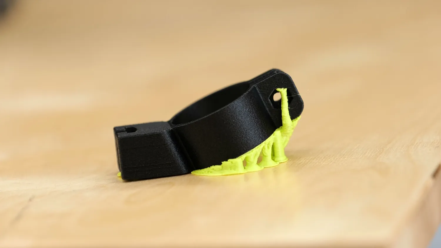 A black carbon fiber nylon bike lock holder with its support material still attached