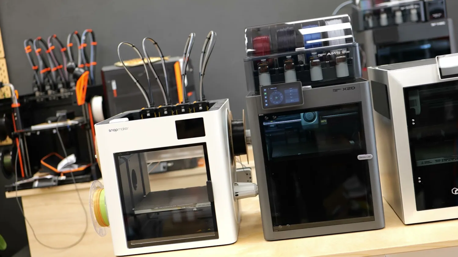 The Snapmaker U1 and the QIDI Q2 standing next to the Bambu Lab X2D