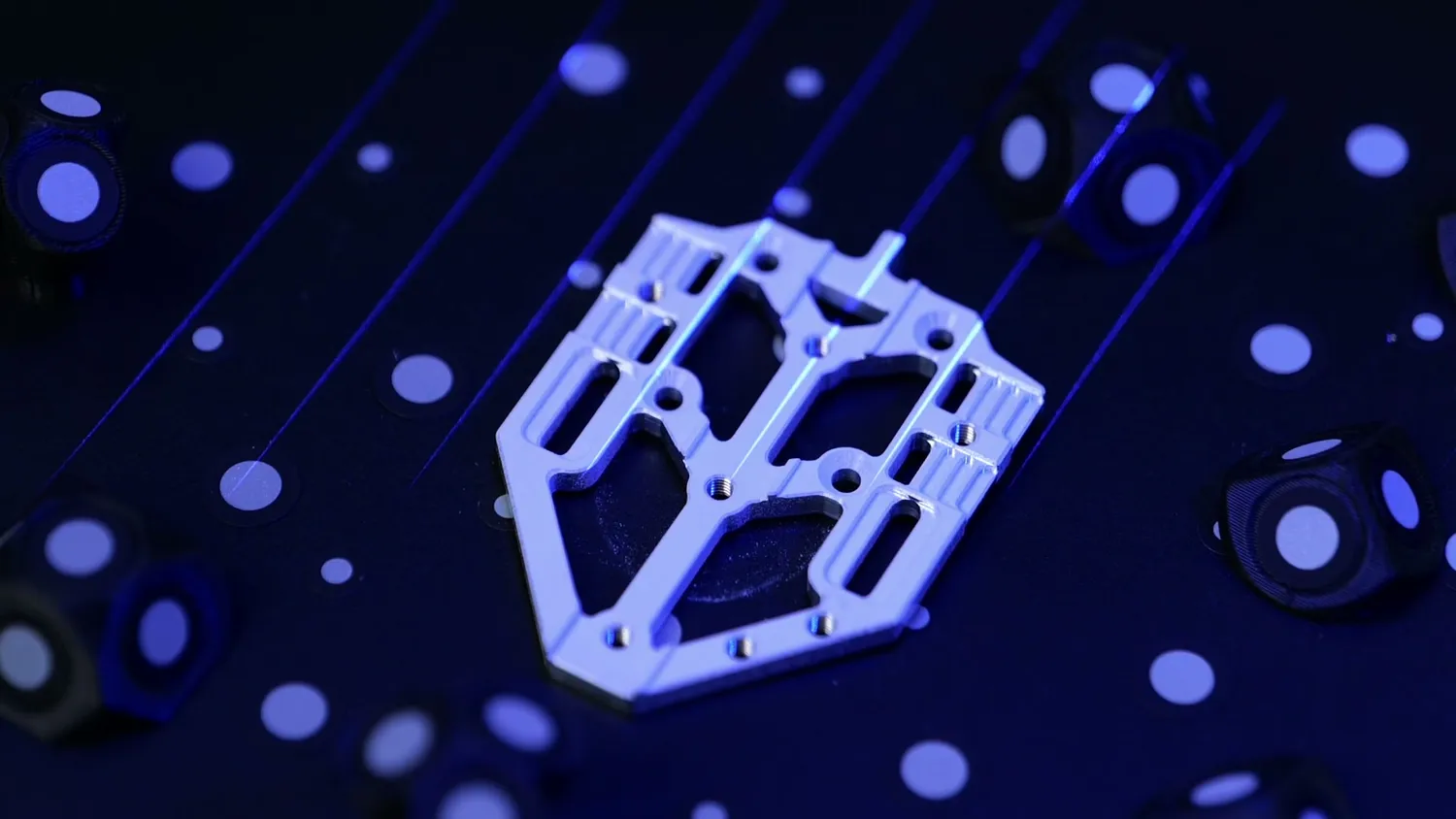 Blue laser lines projected onto a white part with scanning markers