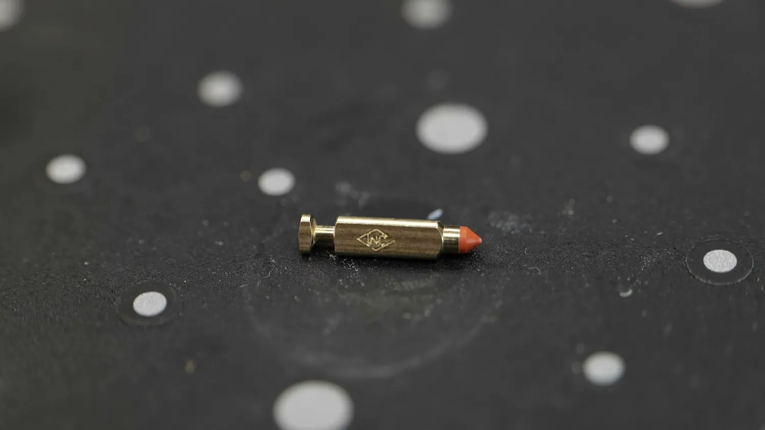 A tiny brass valve sitting on the black scanning plate