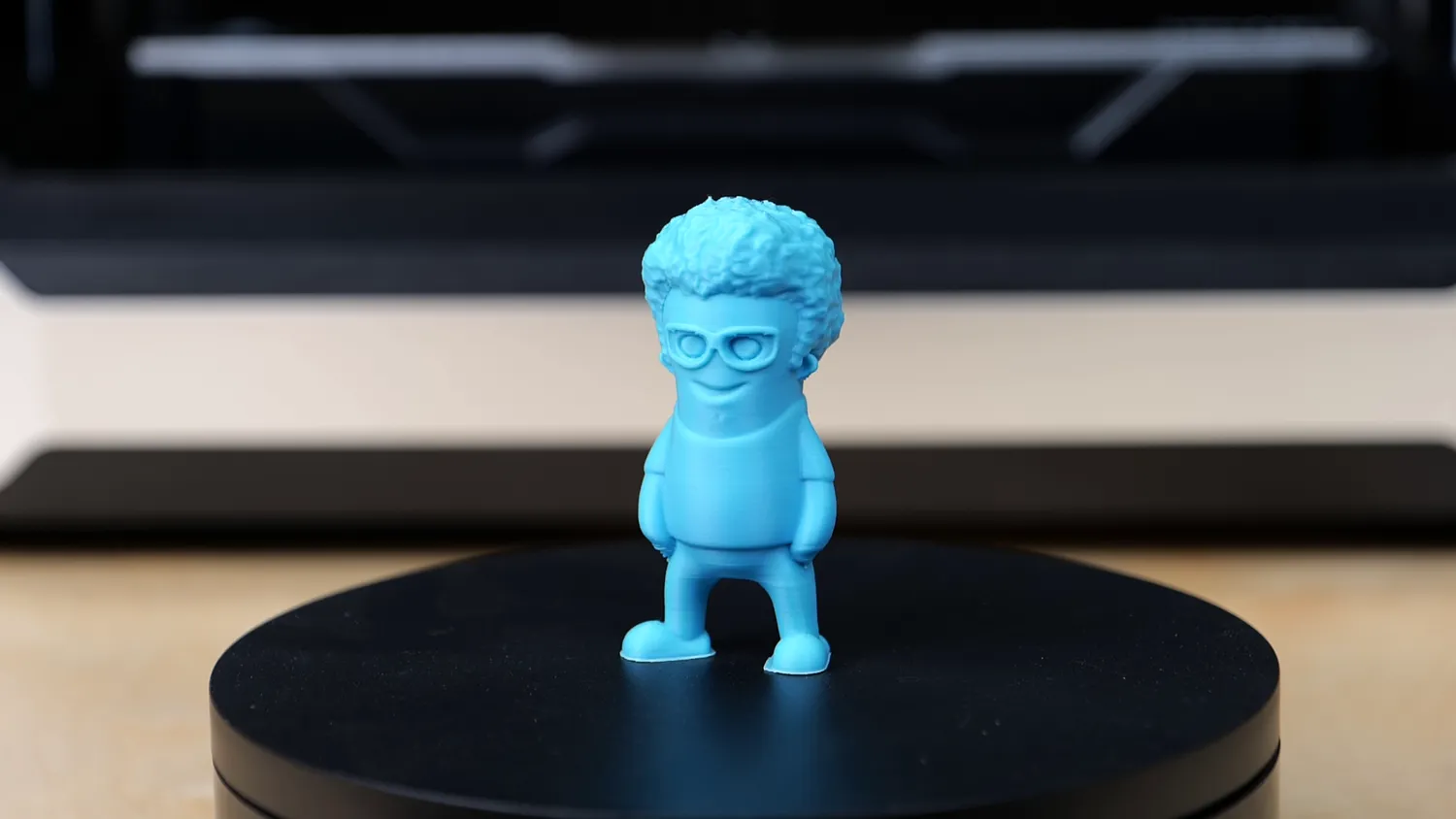 Blue printed figurine with curly hair and glasses