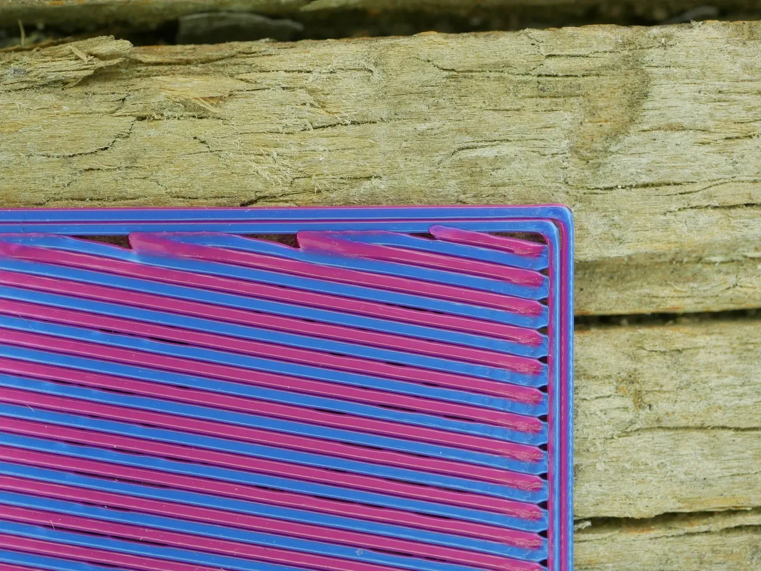 Top surface of a print in pink and blue, where the back-and-forth infill leaves alternating stripes