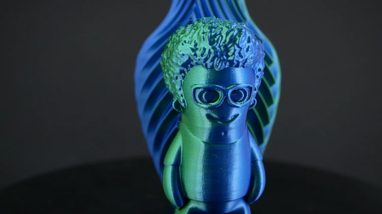 Marvin in blue and green, with a blue and green vase behind