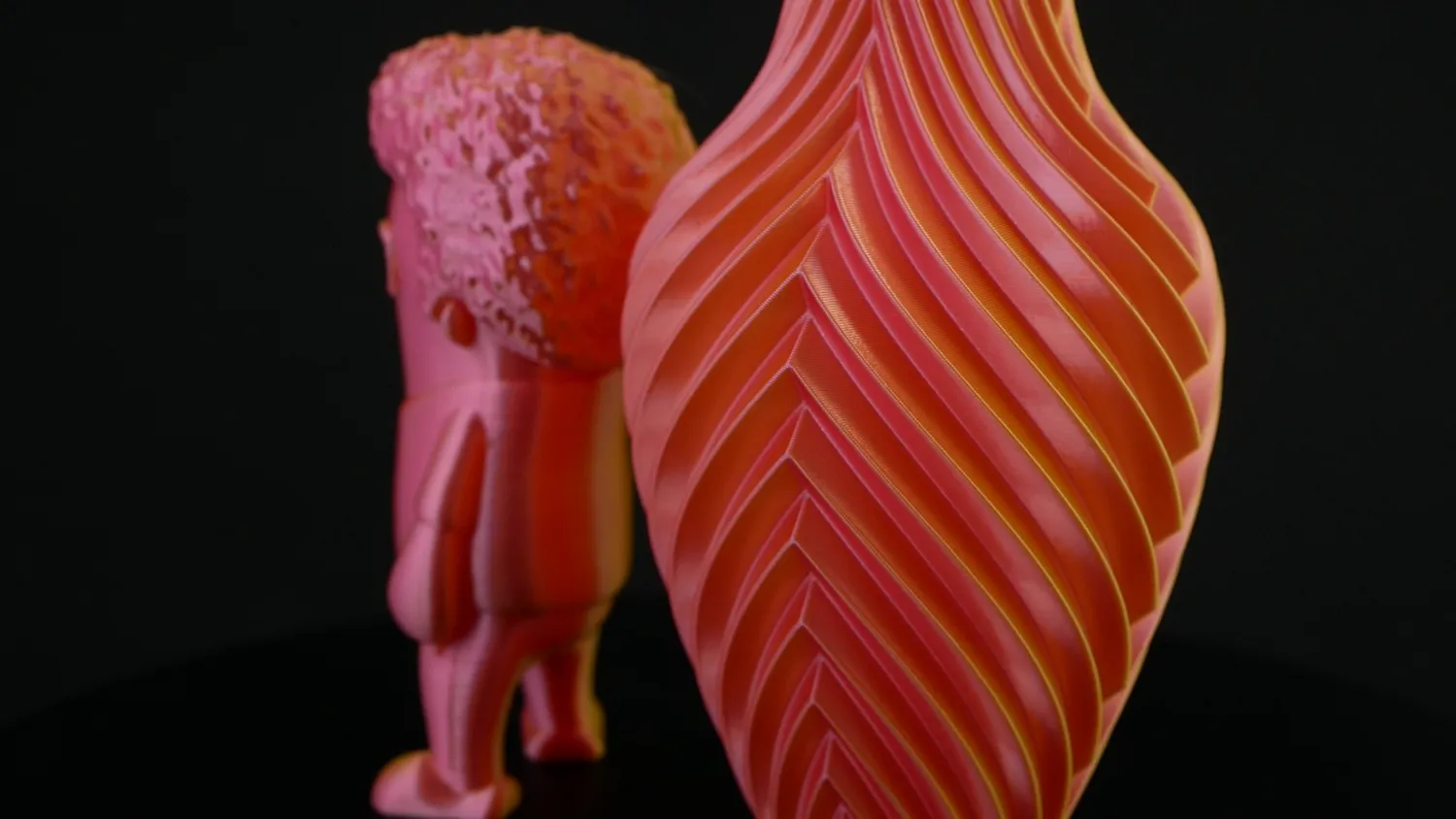 A red and orange vase with the matching Marvin behind it