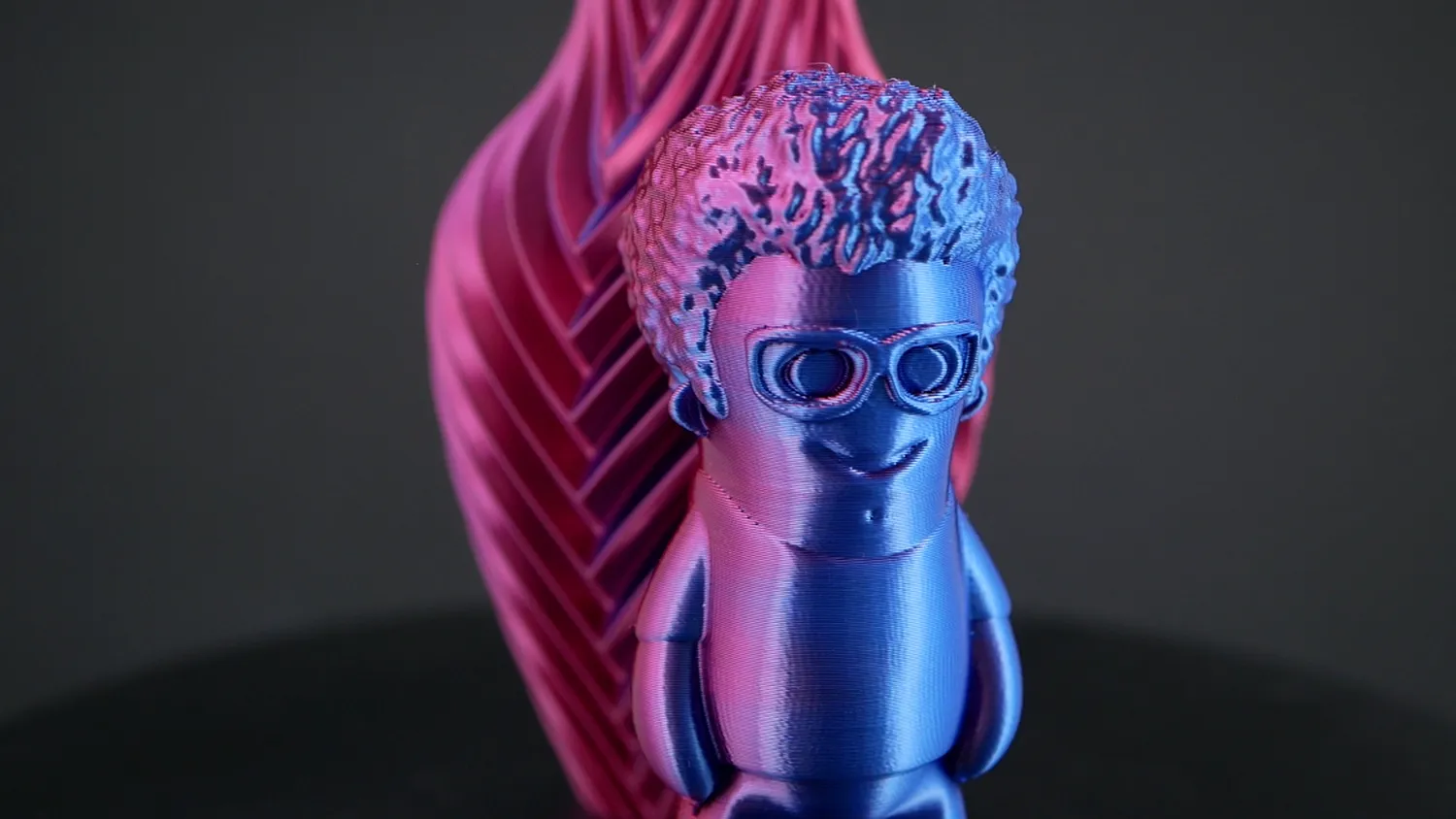 Marvin in pink and blue in front of the pink and blue vase