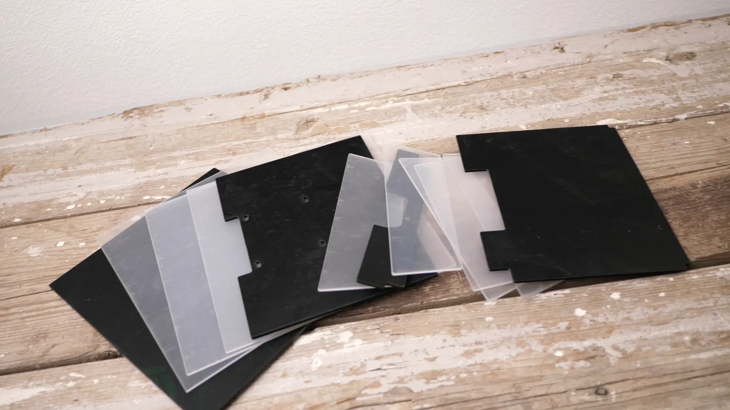 The lasered 2.5 mm acrylic panels, black and clear, fanned out