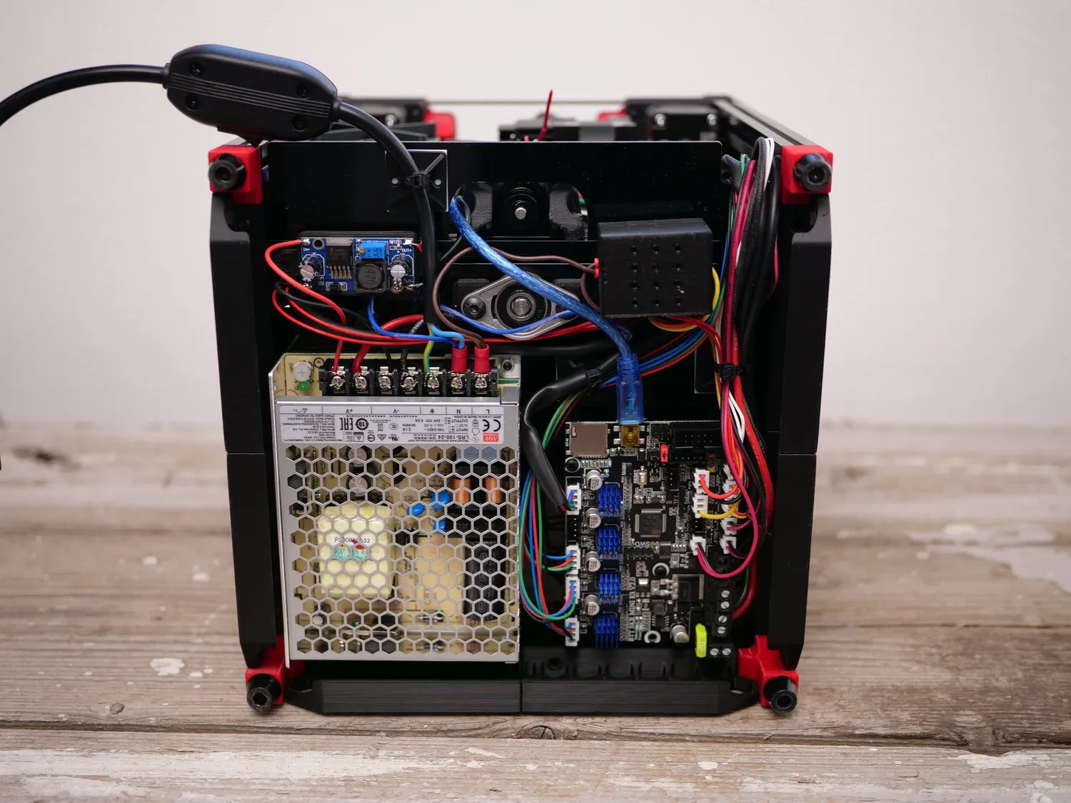 Underneath the printer: power supply and control board with mains wiring exposed