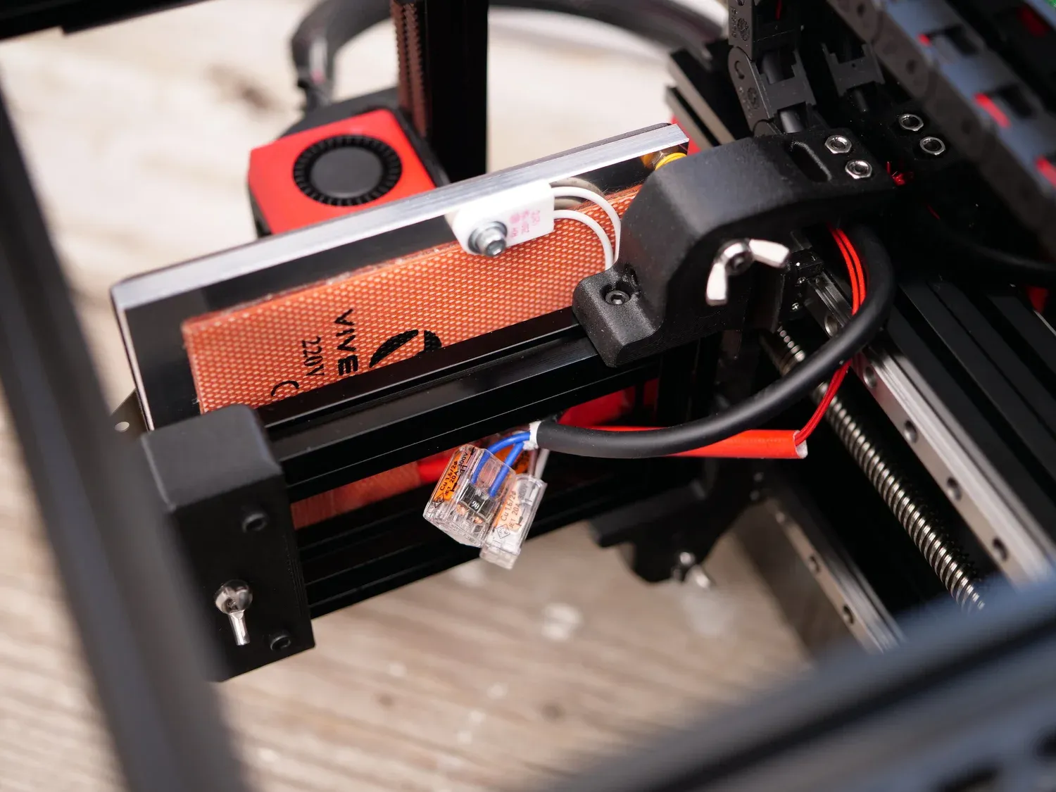 The 220 V silicone bed heater bonded under the build plate