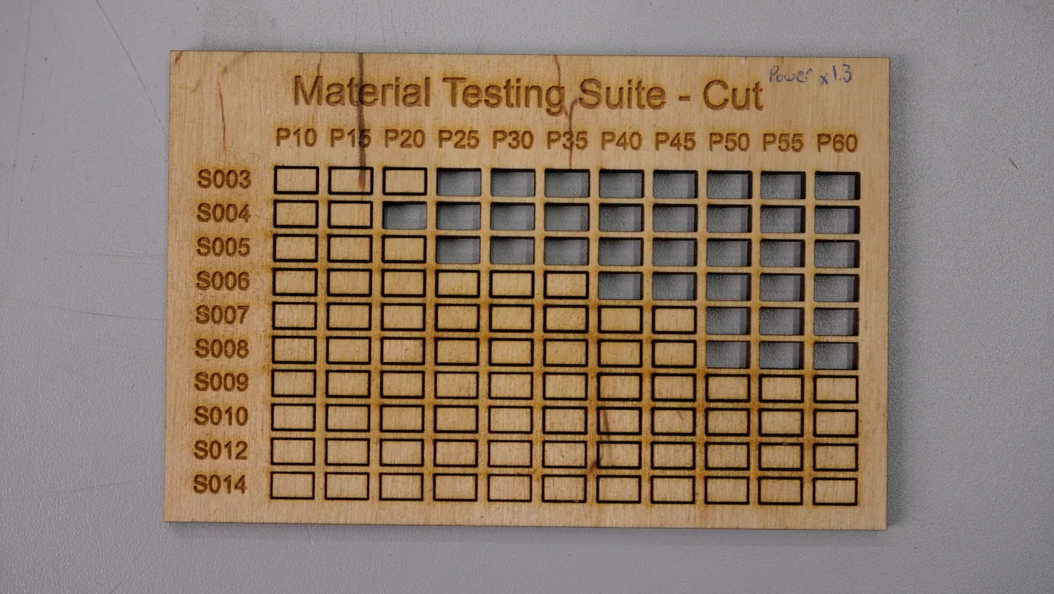 Birch plywood marked Power x1.3, scorched brown and only cut in the top three rows