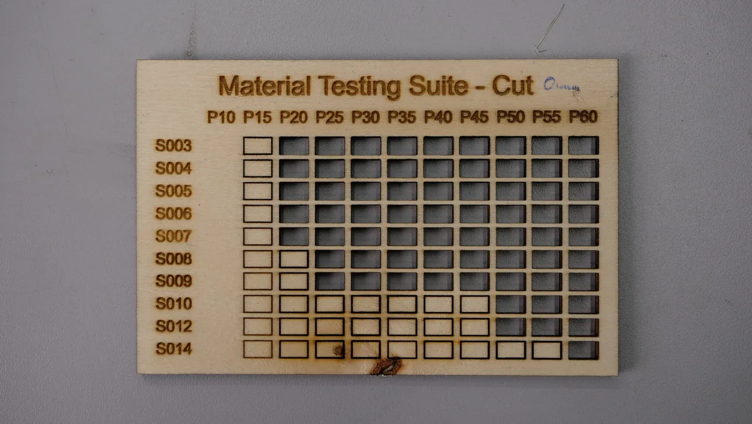 A plywood board cut through from P20 onwards, with one burn mark at the bottom edge