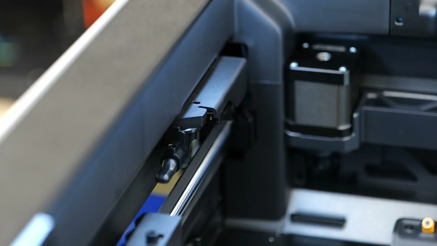 The filament cutter mechanism at the rear of the H2D print bed