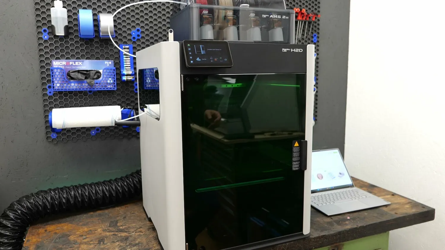 The Bambu Lab H2D set up for laser cutting with the exhaust hose attached