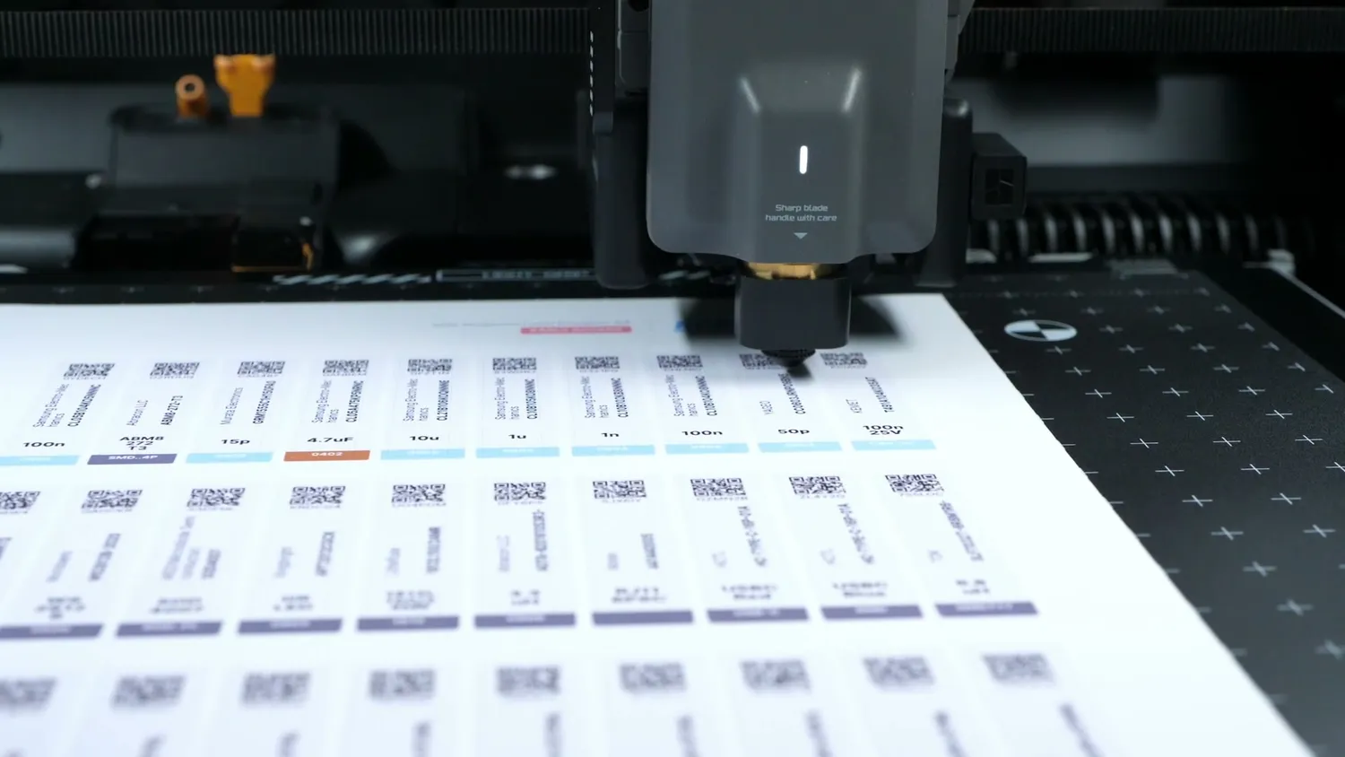 The drag knife of the Bambu Lab H2D cutting a sheet of printed labels