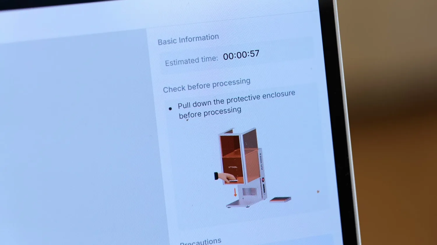 xTool Studio warning on a laptop reading pull down the protective enclosure before processing