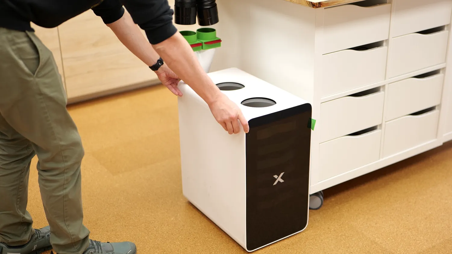 The xTool SafetyPro air purifier standing next to a workshop drawer cabinet