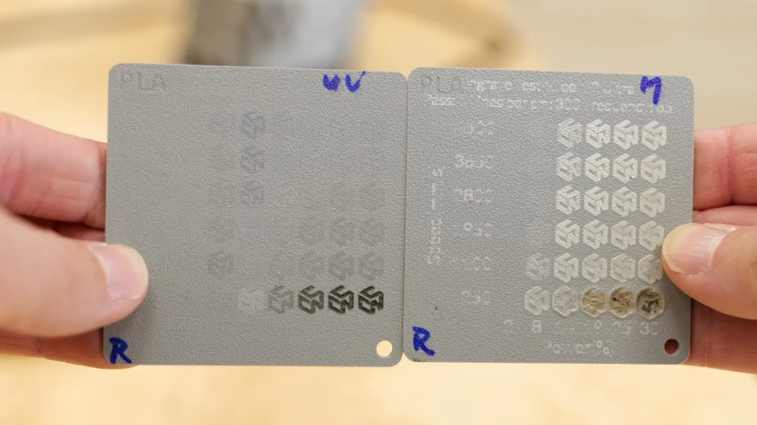 Two light grey test plates side by side, one marked with the UV laser and one with the MOPA