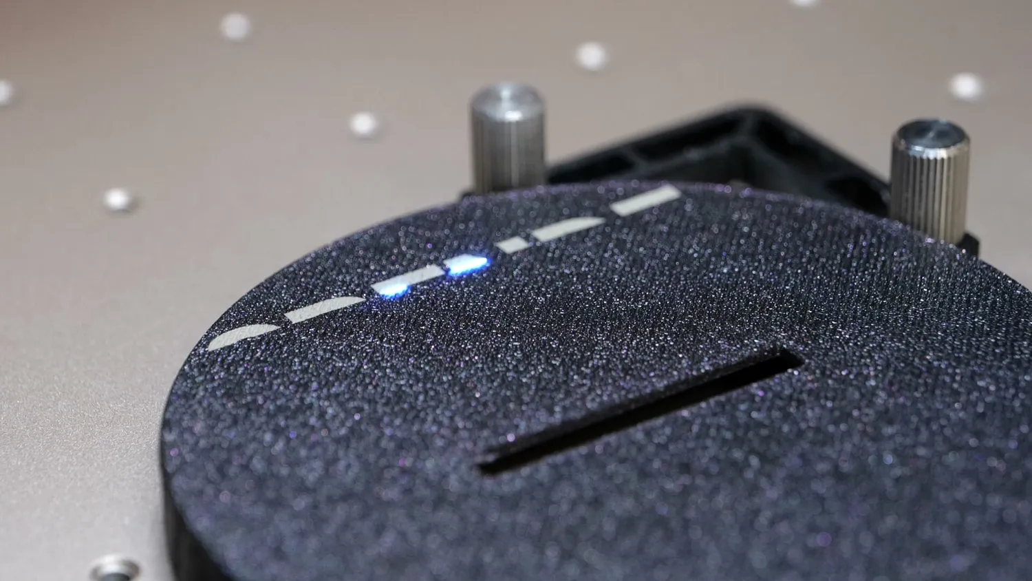 The UV laser marking a dashed line into a black printed donation box