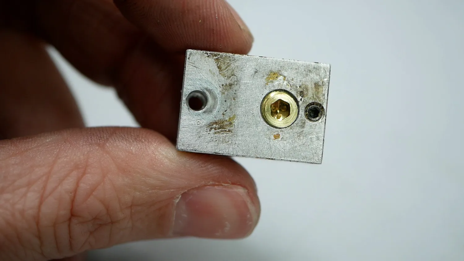 The grub screw held flush in an old heater block, used as a jig for facing