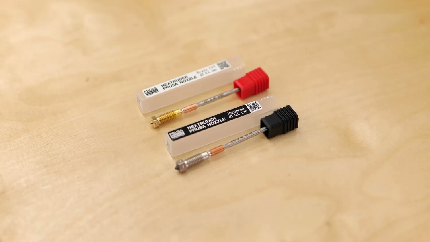The two included nozzles in their plastic tubes on the workbench