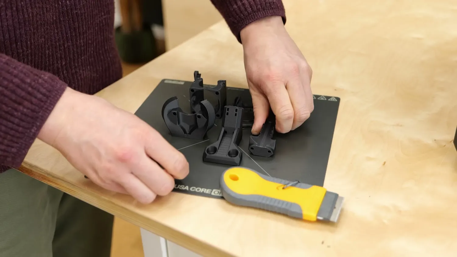 Printed parts being popped off the satin PEI sheet with a scraper