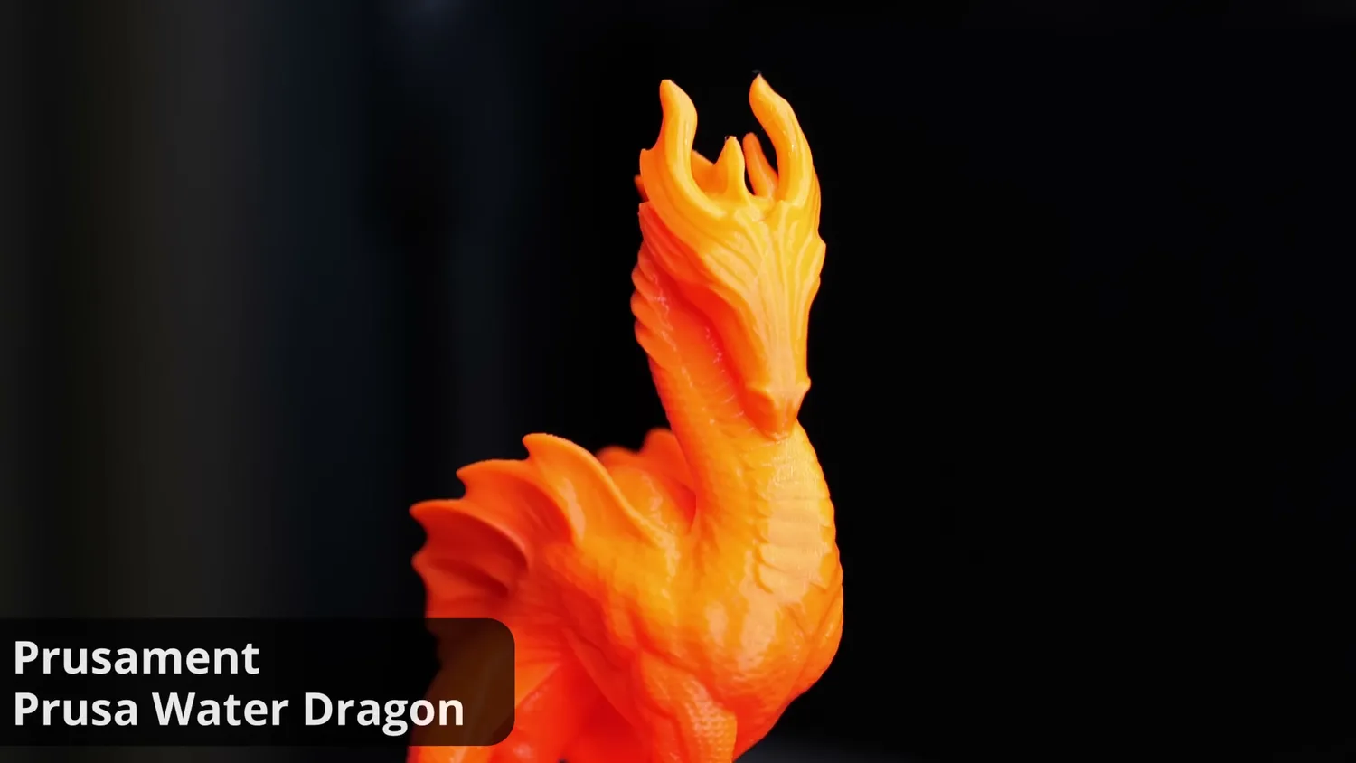 The orange Prusament water dragon on a turntable, its scales and fins crisply resolved