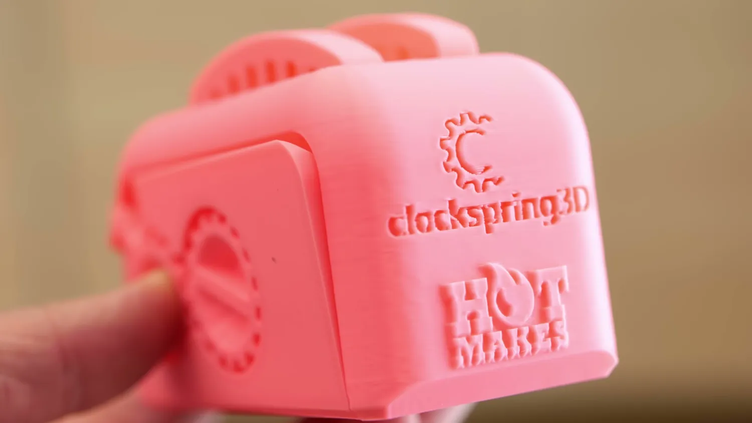 The pink Torture Toaster in close-up, its embossed Clockspring3D logo sharply printed