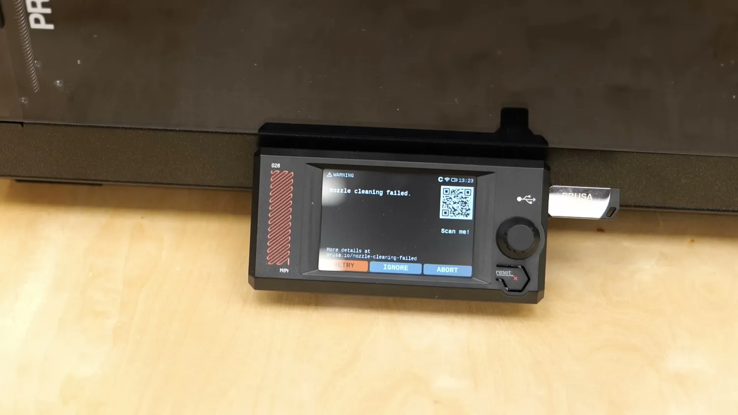 The printer screen showing a "Nozzle cleaning failed" error with a QR code