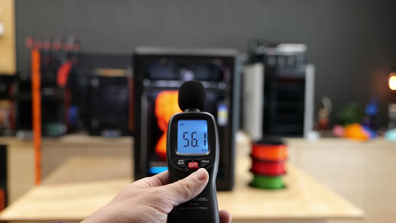 A sound level meter reading 56.1 dBA in front of the printing CORE One L