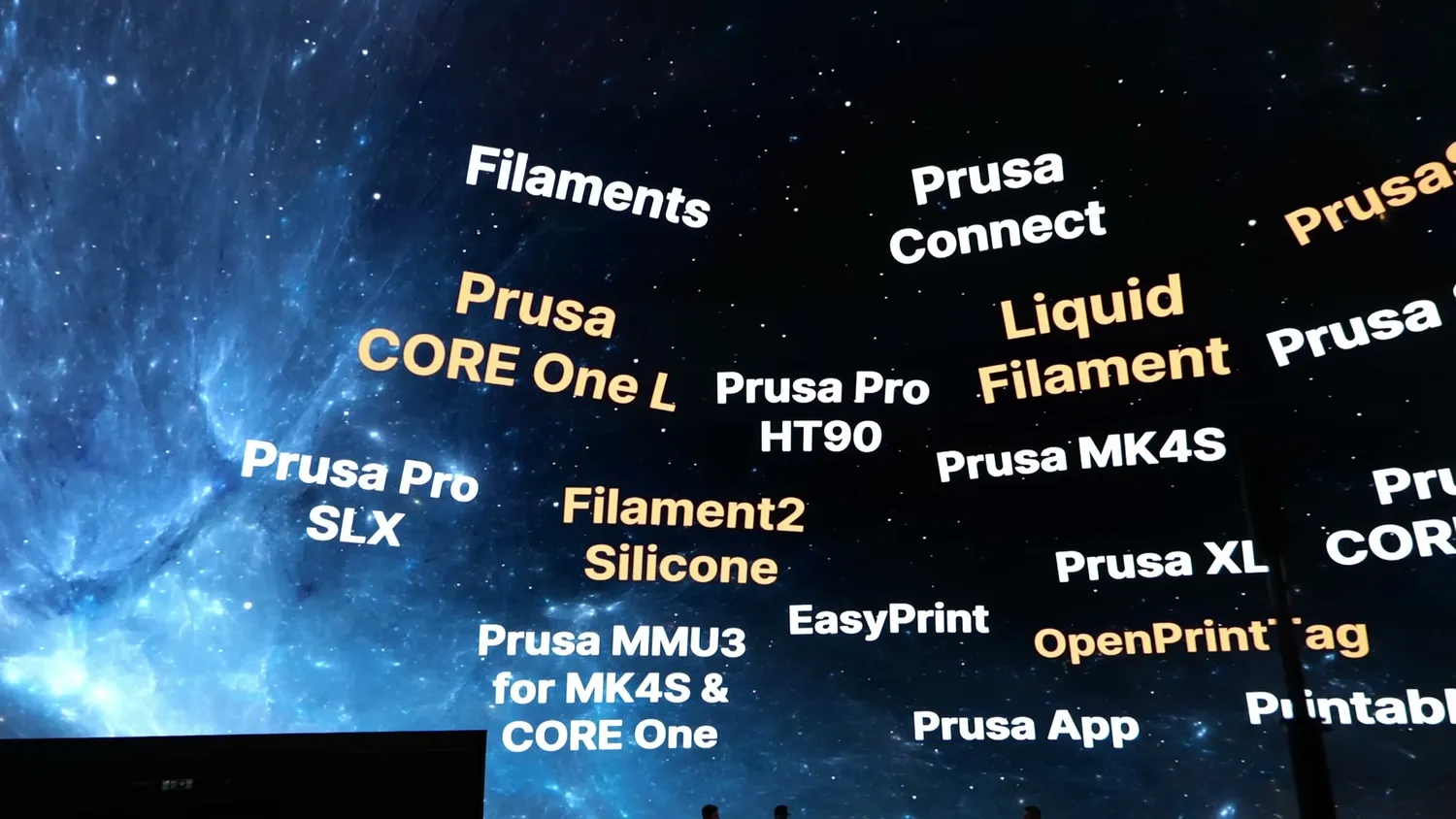 The Prusa product line-up projected across a starfield at the Prague event