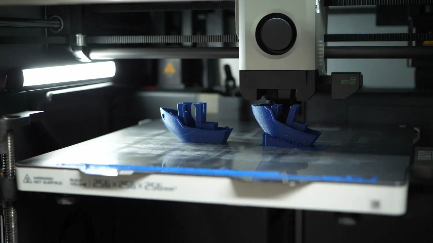 Two 3DBenchy prints tilted on the build plate