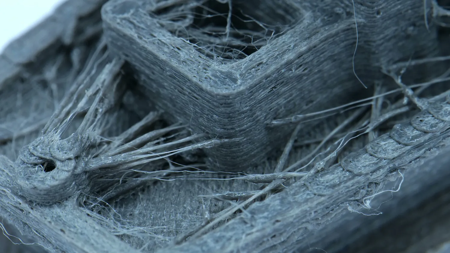 Close-up of a print covered in strings and blobs from wet filament