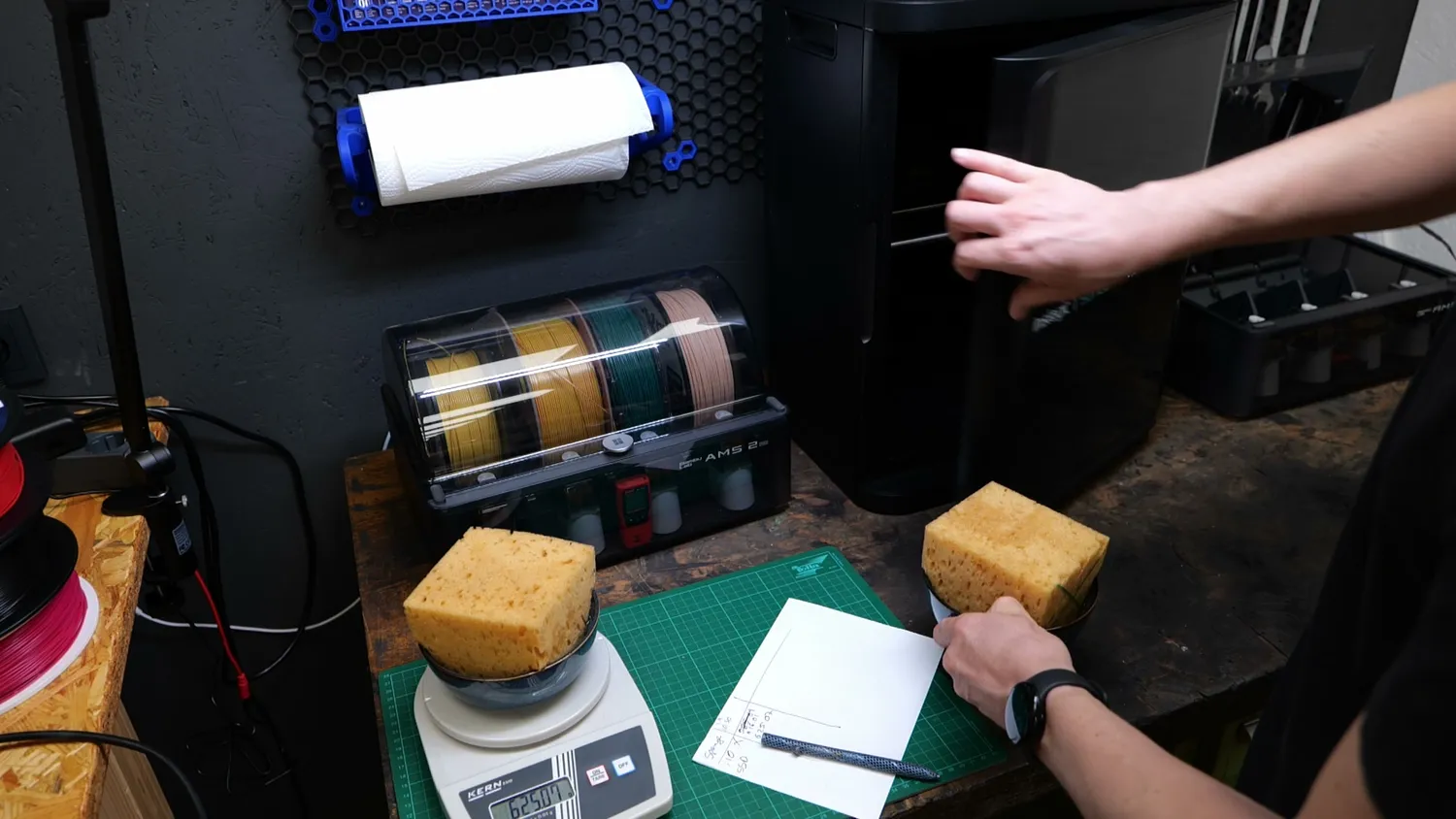 Weighing a wet sponge on a scale in front of the AMS and the i10