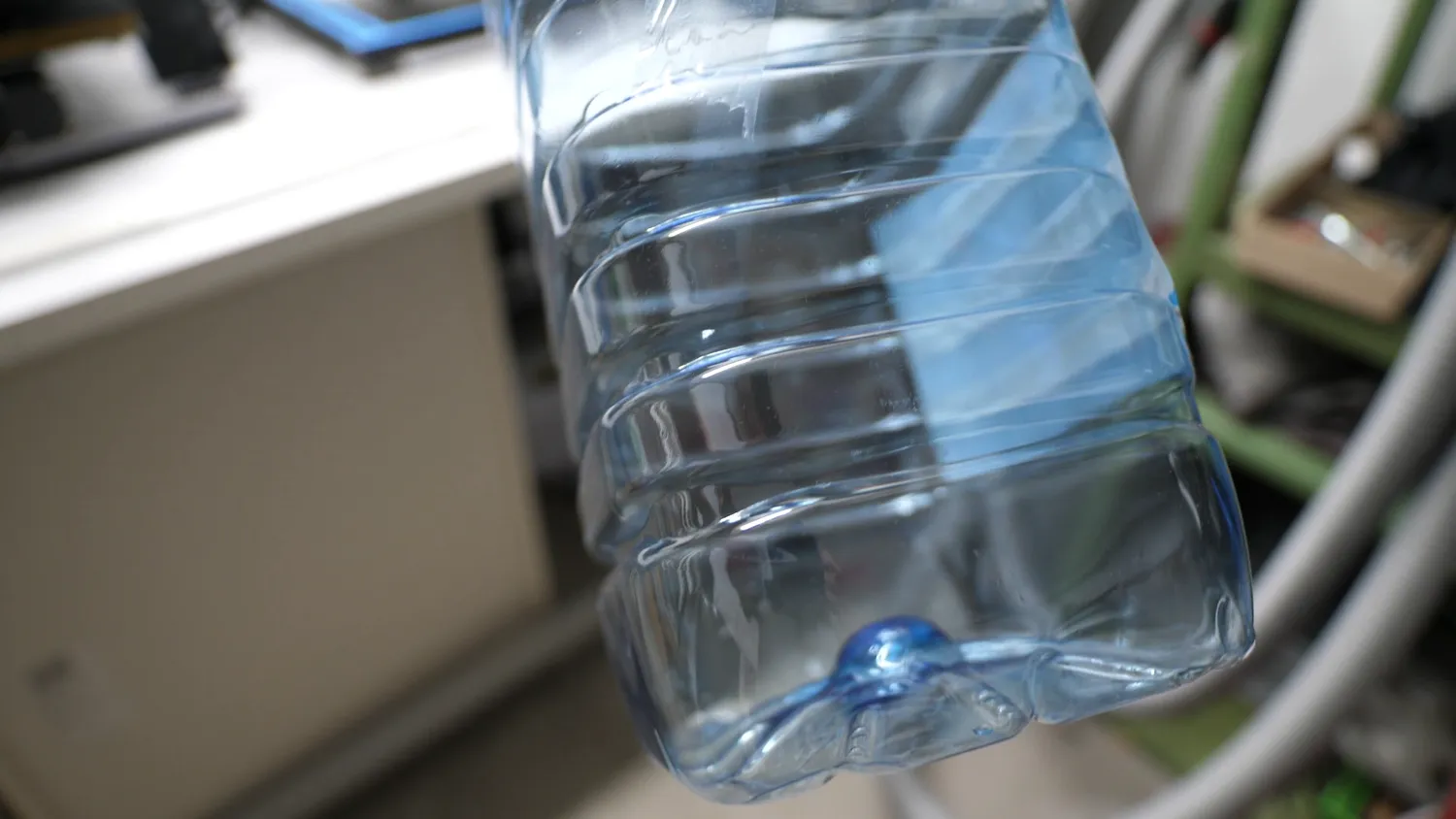 Circumferential ribs around the base of a PET water bottle