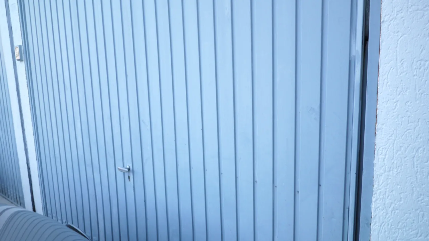 Vertically corrugated sheet metal garage door
