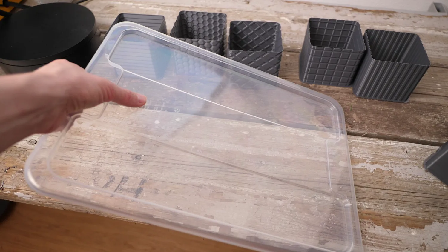 Ribbed clear plastic box lid, with the textured printed cubes behind it