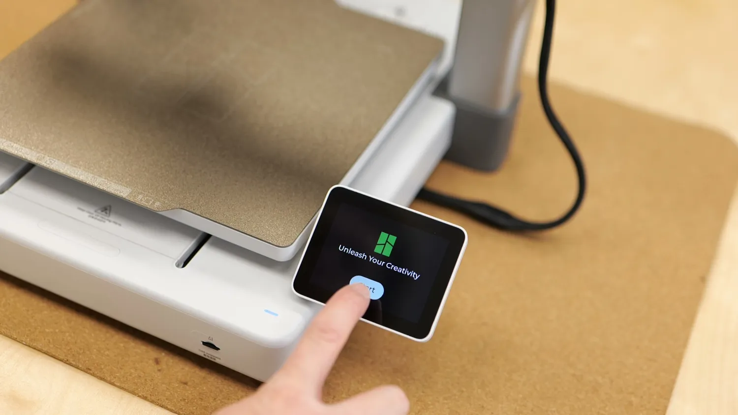 Finger tapping the touchscreen of a 3D printer during first start-up