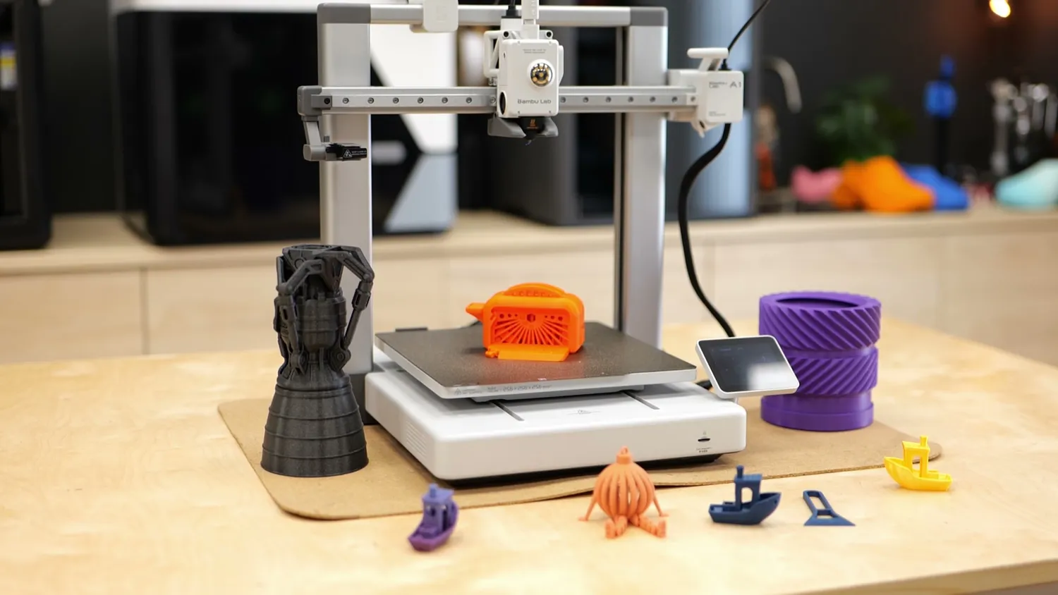 3D printer surrounded by a collection of colorful 3D printed objects