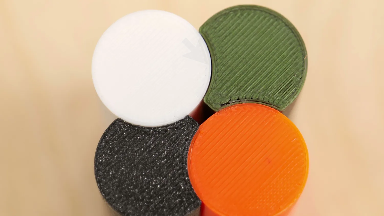 Four printed discs in white, green, black and orange